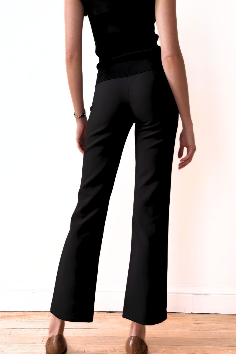 Model wearing a black outfit against a plain background side view
