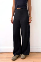 Model wearing navy wide-leg pants and a dark top against a plain background
