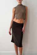 Model wearing a taupe sleeveless top and brown skirt 