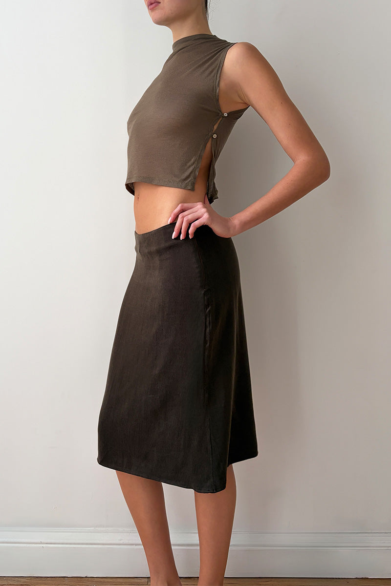 Side view of model wearing a taupe sleeveless top and brown skirt 