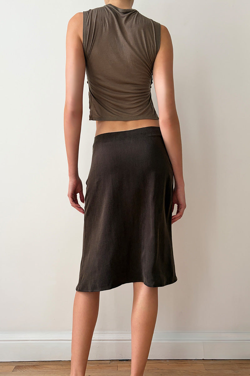 Back view of model wearing a taupe sleeveless top and brown skirt 
