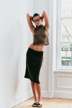 Model wearing a taupe sleeveless top and brown skirt 