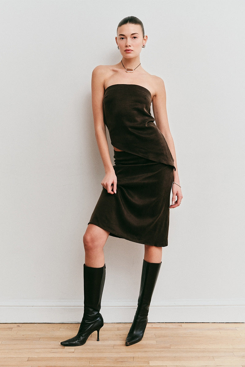 Model wearing a brown strapless top and brown skirt 