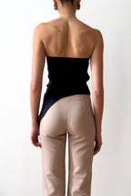 Model wearing strapless drape asymmetric top in navy