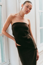 Model wearing a brown strapless top and brown skirt 