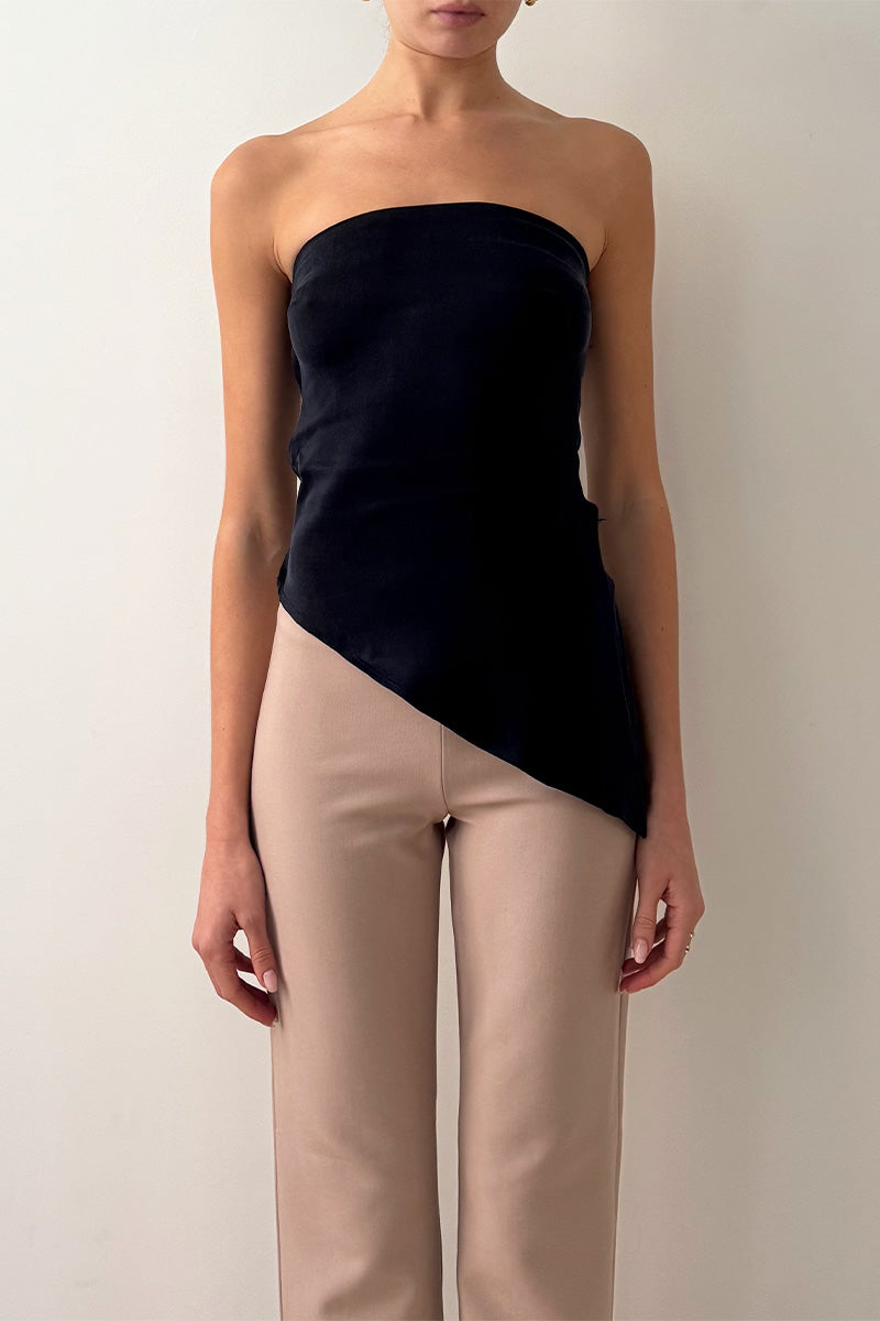 Model wearing strapless drape asymmetric top in navy
