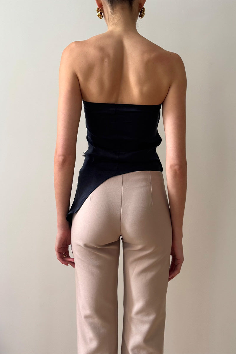 Back view of model wearing strapless drape asymmetric top in navy