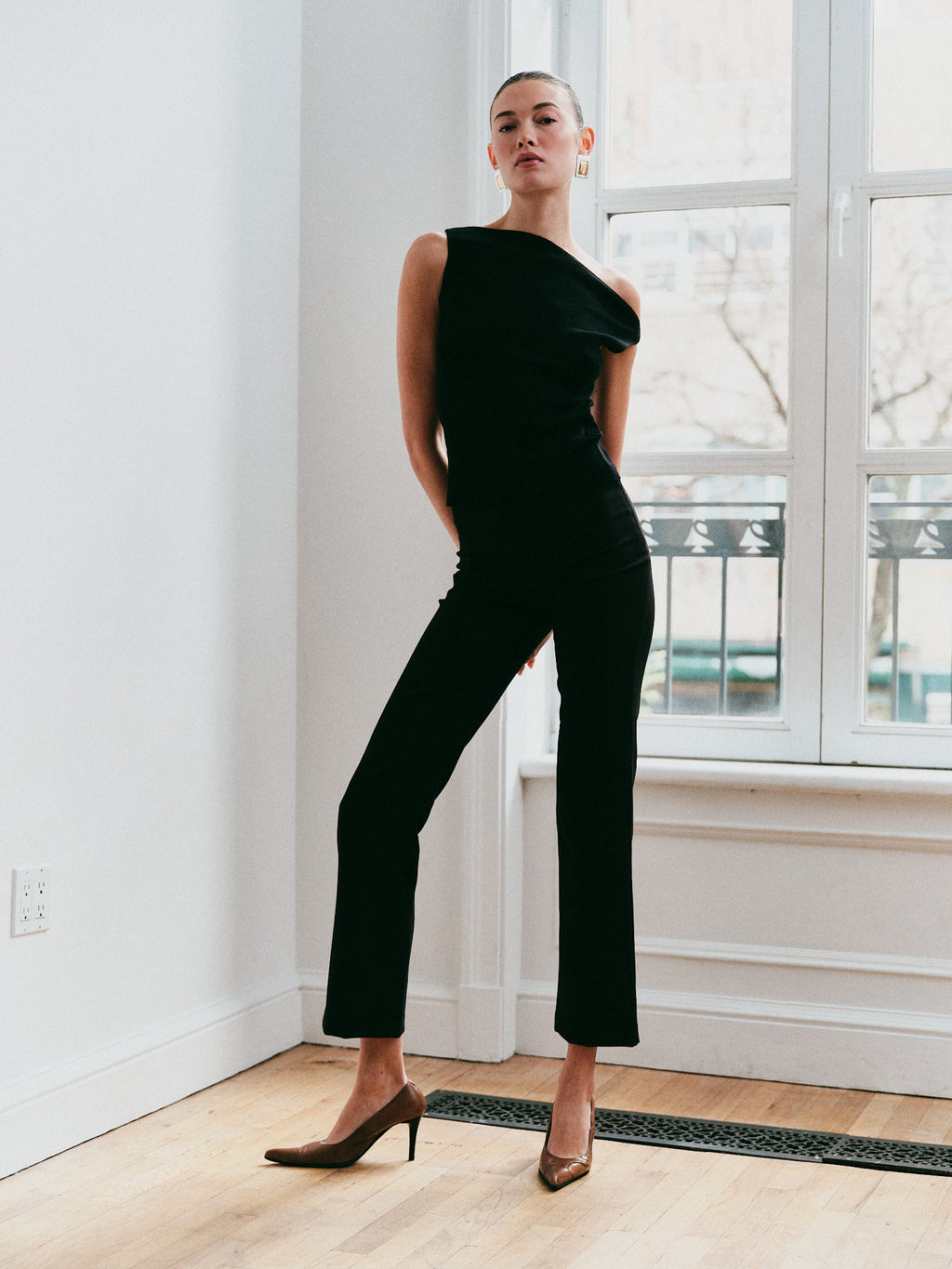 Woman wearing a black one-shoulder top and black pants