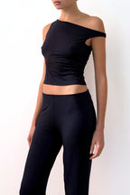 Model wearing a navy off-shoulder top and navy pants against a plain background