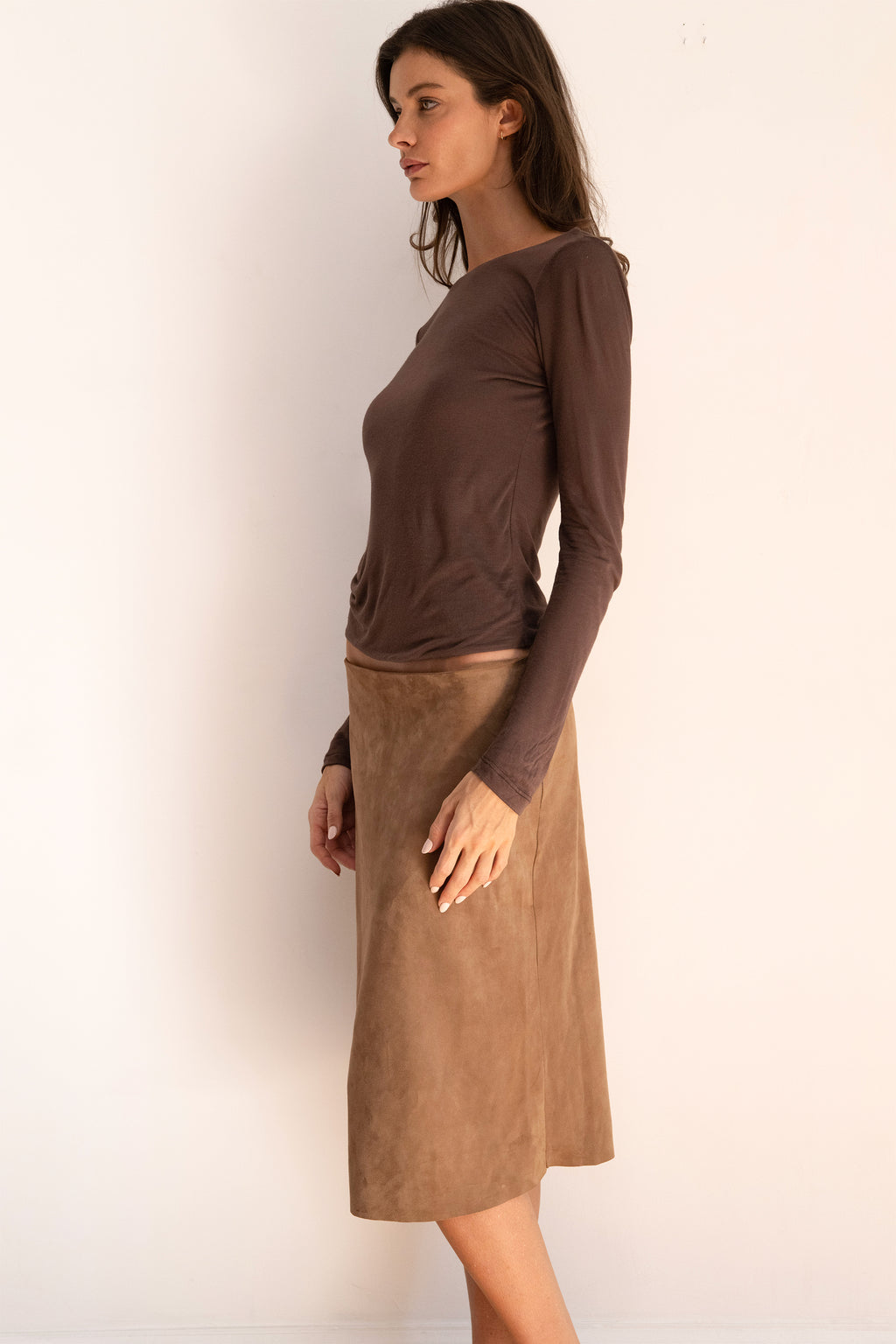 Model wearing the espresso Twist Top with a boat neckline, long sleeves, and a softly fitted silhouette.