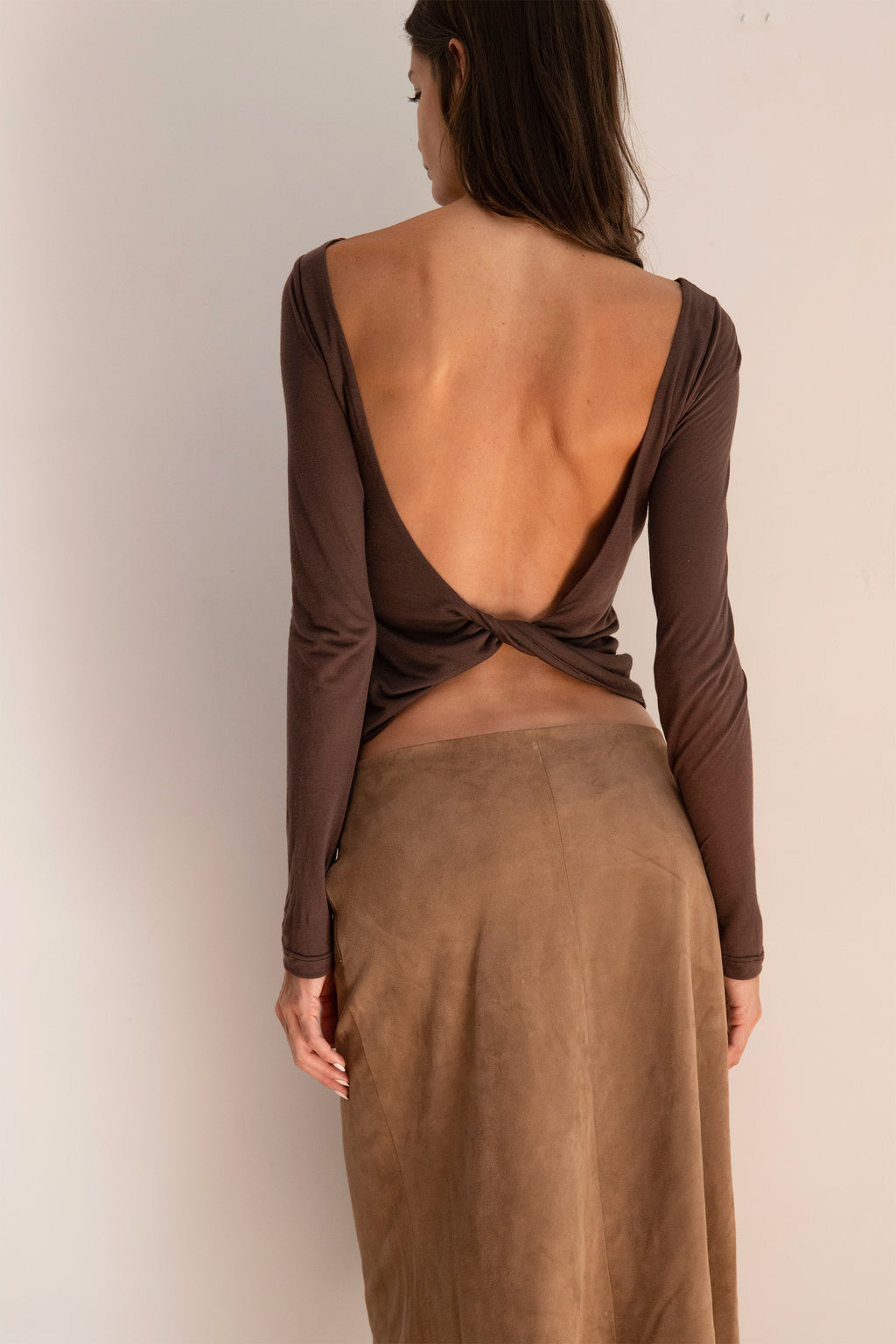Model wearing the espresso Twist Top with a boat neckline, long sleeves, and a softly fitted silhouette.