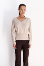 Beige Ease Sweater in a wool and cashmere blend, featuring a V-neckline, relaxed shoulders, and a fitted ribbed waistband.