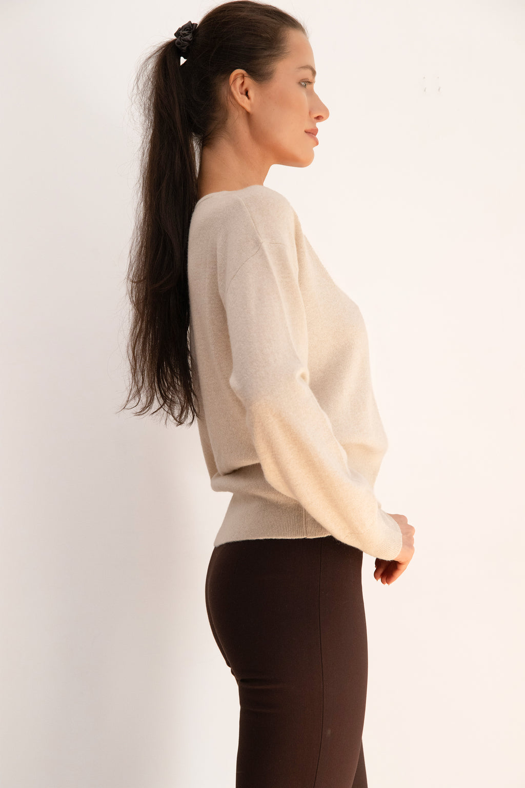 Beige Ease Sweater in a wool and cashmere blend, featuring a V-neckline, relaxed shoulders, and a fitted ribbed waistband.