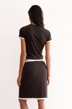 Model wearing the Remi Skirt in espresso brown with ivory contrast waistband and hem, styled low on the waist