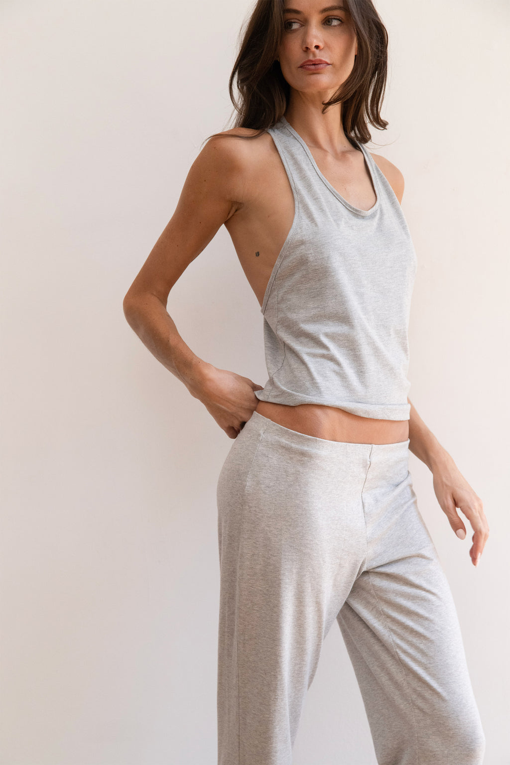 Model wearing a light heather gray tank top and matching light heather gray jogger pants