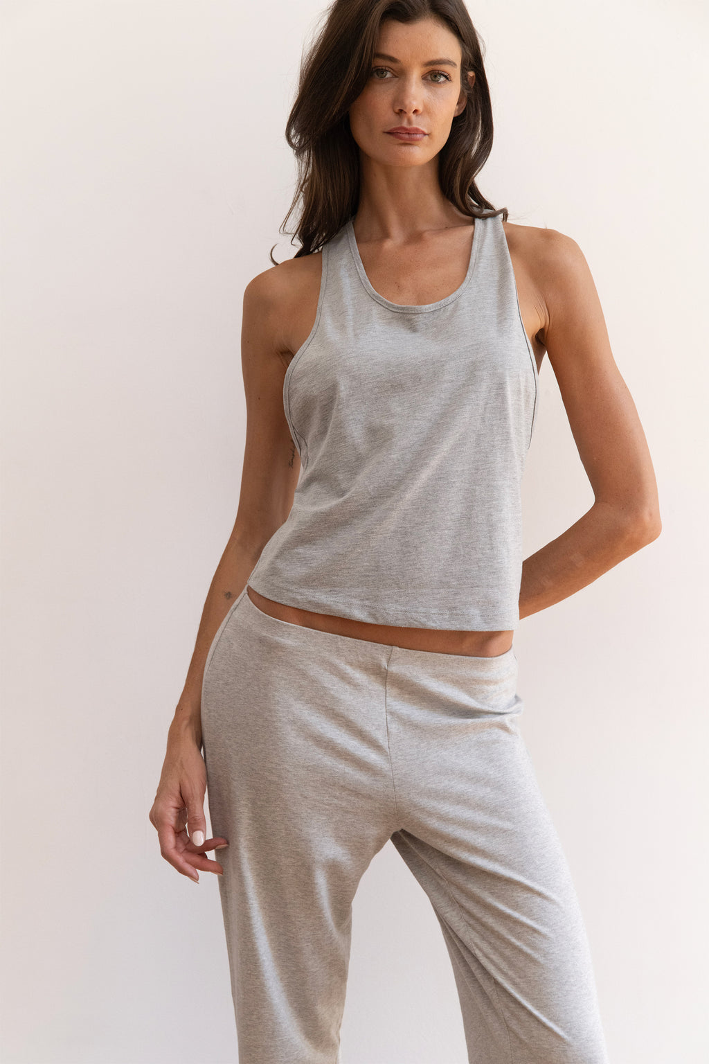 Model wearing a light heather gray tank top and matching light heather gray jogger pants