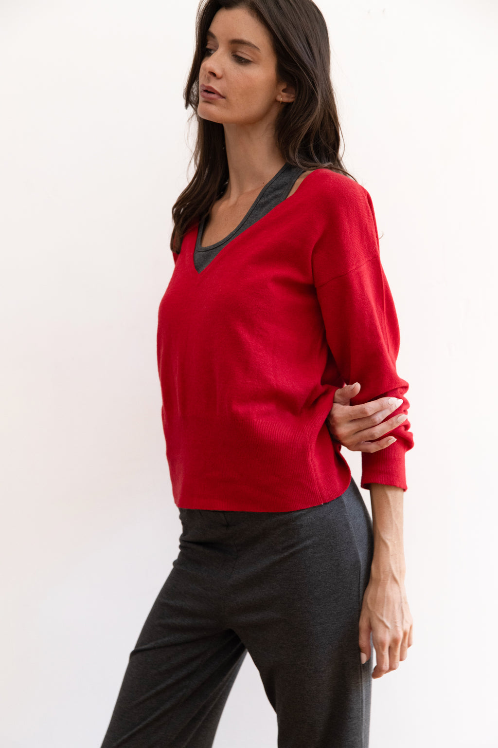 Model wearing a red vneck sweater with charcoal sweater set 