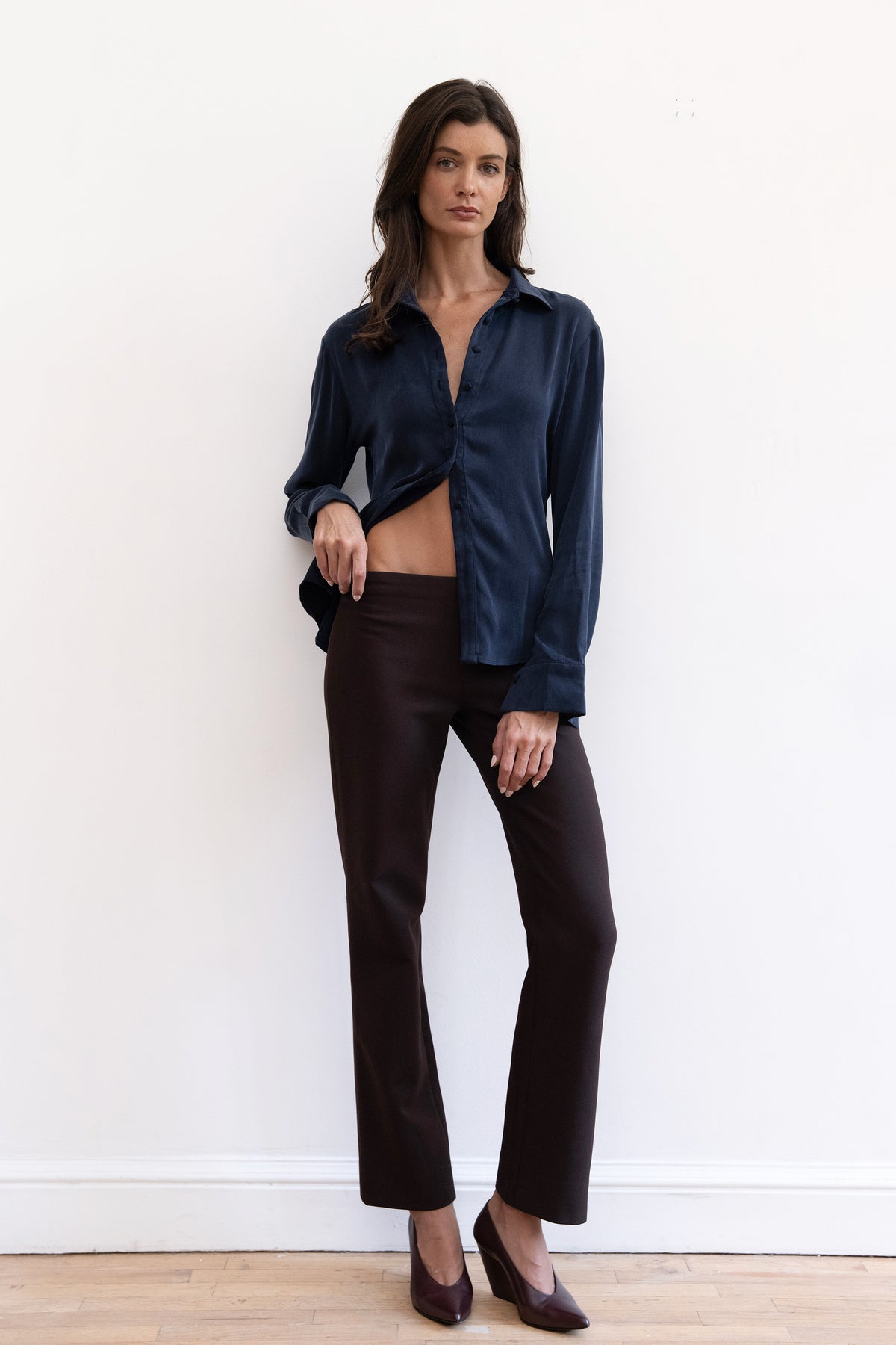 Model wearing espresso contour pants and navy cupro synched waist button down shirt
