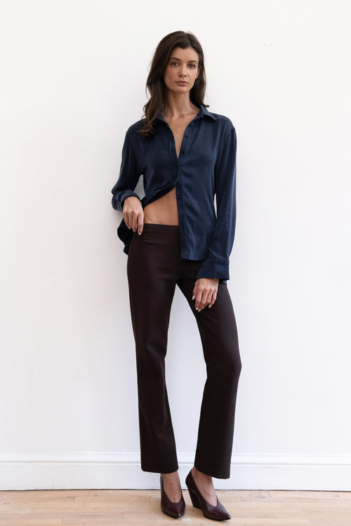 Model wearing espresso contour pants and navy cupro synched waist button down shirt