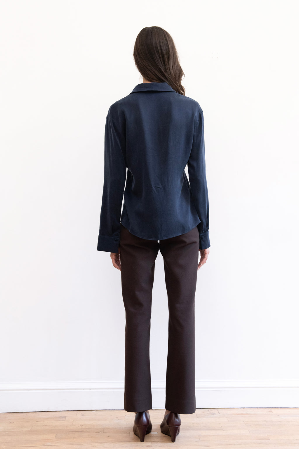 Model wearing espresso contour pants and navy cupro synched waist button down shirt