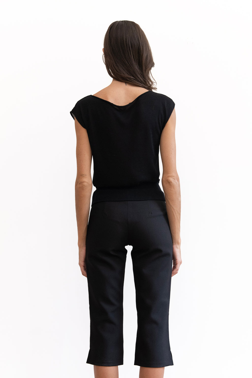A woman modeling a black off-the-shoulder short-sleeve knit with capri-length legs