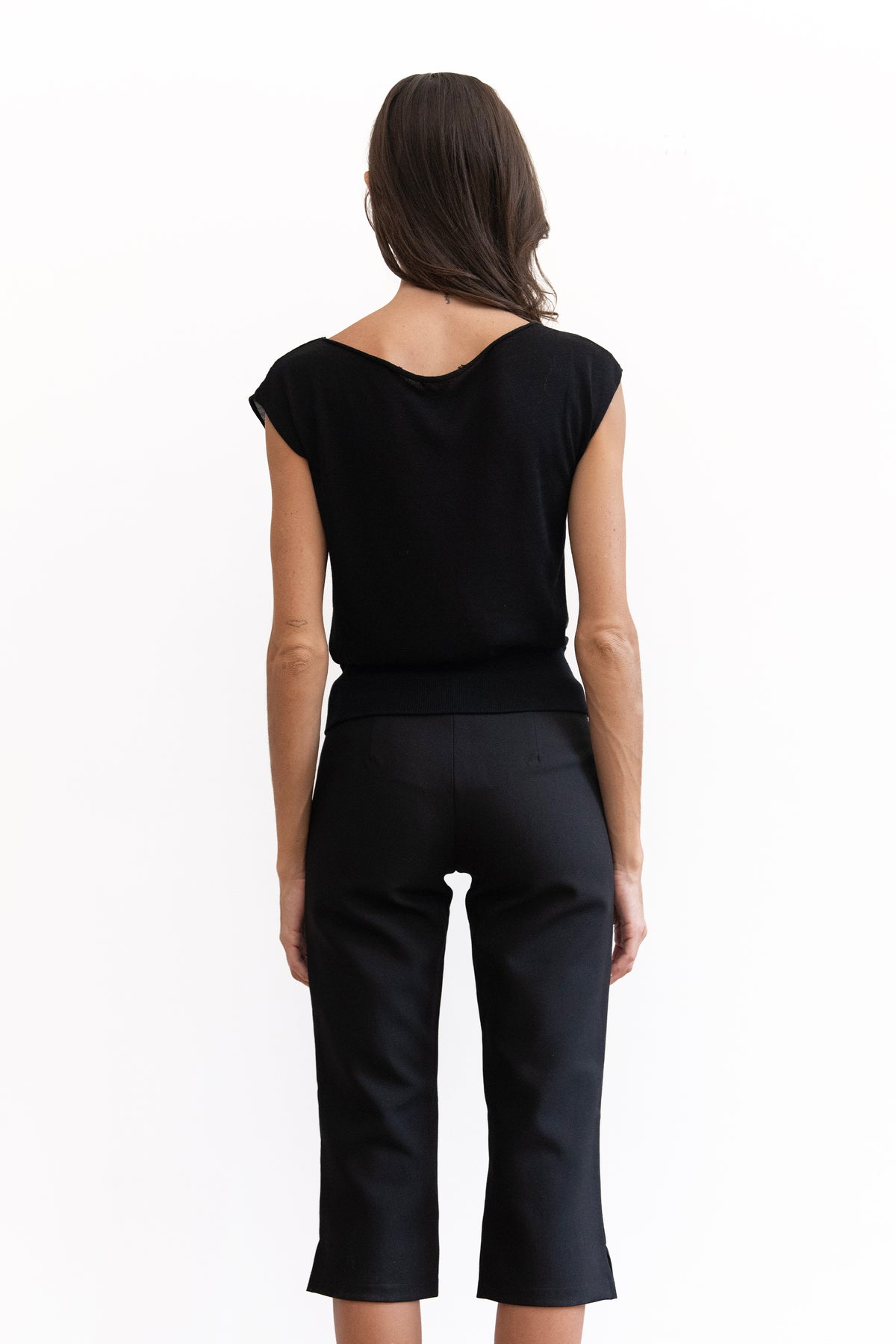 A woman modeling a black off-the-shoulder short-sleeve knit with capri-length legs