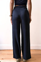Model wearing navy wide-leg pants and a dark top against a plain background