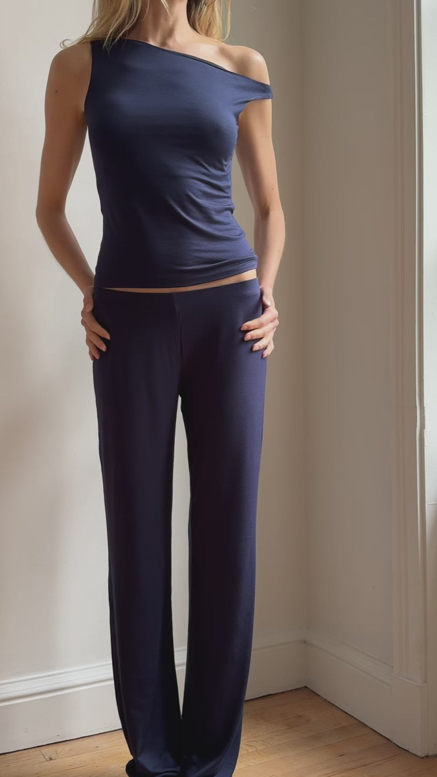Model wearing the Still Micromodal Pant in navy, a soft low-rise straight-leg pant styled with matching top and leather loafers.
