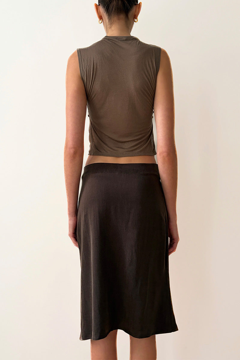 Model wearing a brown sleeveless top and skirt on a plain background